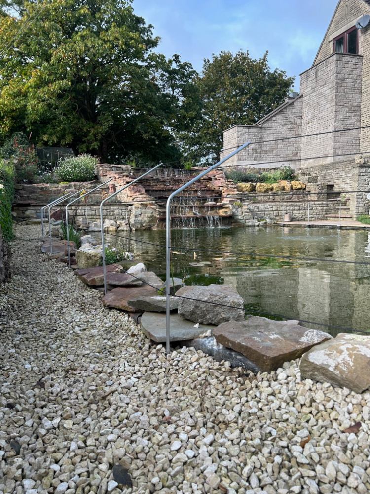 Waterfall steps into pond with predator fencing